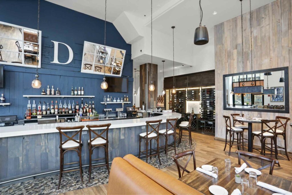 a shot of Divina restaurant with booths in the foreground and the bar in the background