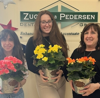 Smiling female staff holding flowers