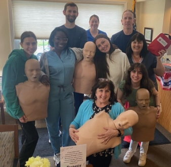 Group photo of staff and doctors with CPR dummies