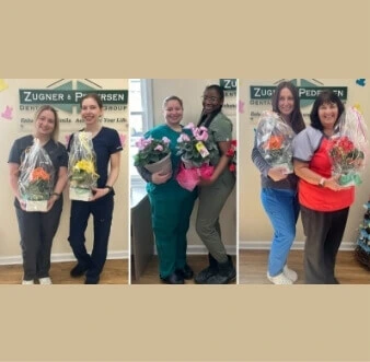 Six female staff members holding flowers