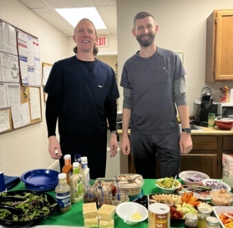 The doctors in front of a table laden with party food
