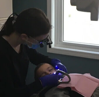 Rebekah cleaning a young person's teeth