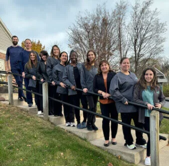 The staff standing on the steps outside of their office