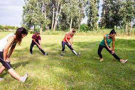 a group of adult women exercising outdoors