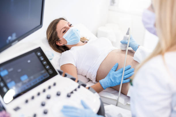 Ultrasound pregnancy examination of young woman in a Medical Clinic during Covid 19 outbreak.