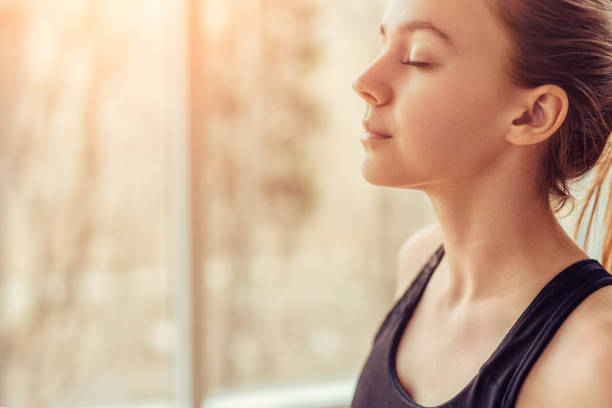 a photograph of a woman managing her stress productively through deep breathing, which is a healthy habit for the new year!