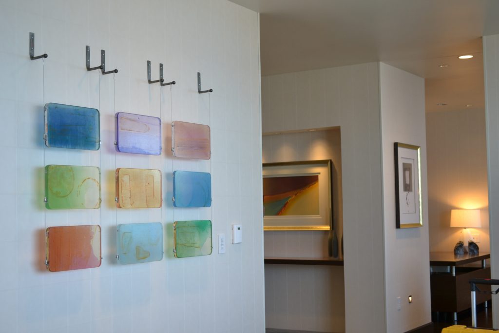 different pieces of artwork and framed paintings on the wall of a hotel room