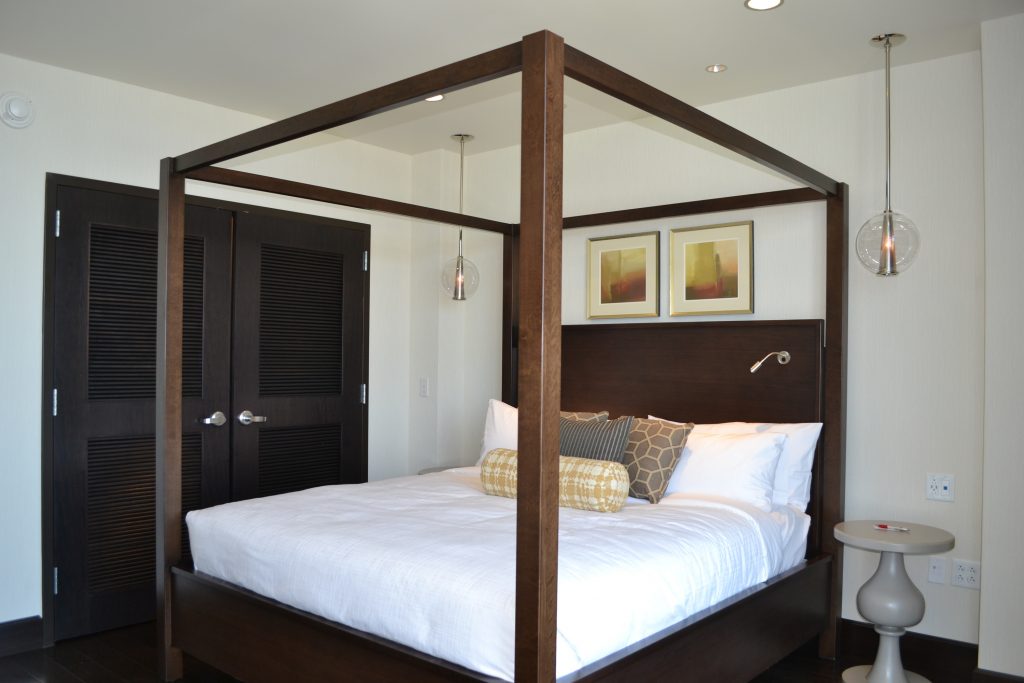 framed artwork above a canopy bed